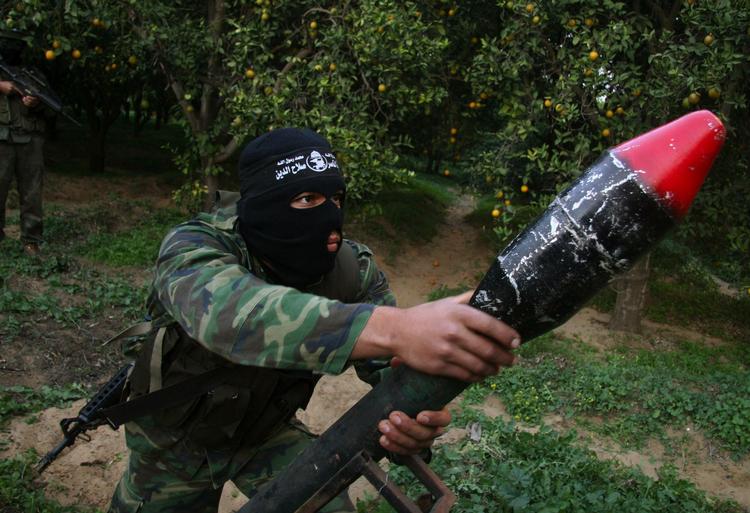 En maskeret palæstinenser viser en hjemmelavet raket frem i Gaza. 