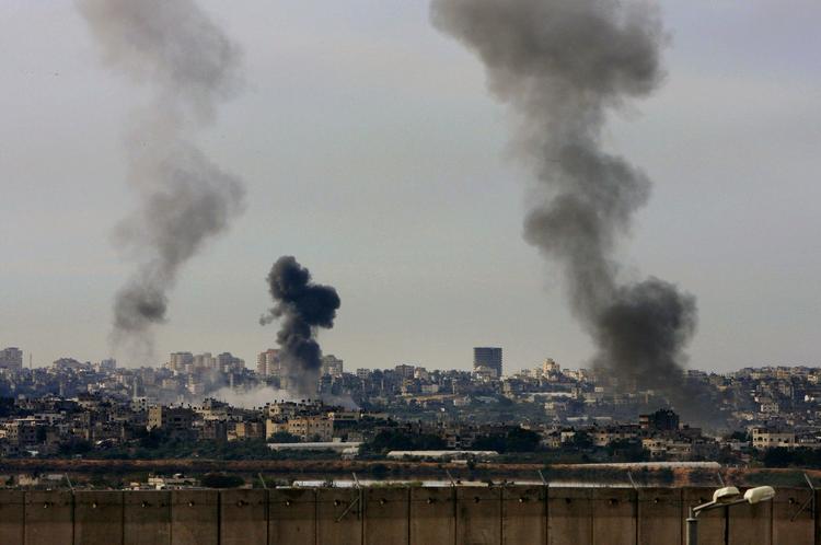 Røg stiger op efter luftangrebet mod Gaza By. Her fotograferet ind over sikkerhedsmuren mellem Israel og de palæstinensiske områder. 