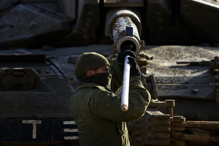 En israelsk soldat på arbejde  ved Gazastriben efter det luftangreb, der har dræbt mindst 280 palæstinensere. 