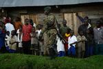 Børn og mænd i det østlige DR Congo venter på, at en FN-helikopter med Nigerias tidligere præsident Laurent Nkunda skal lande for at tage del i fredsprocessen. 