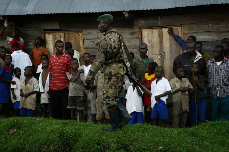 Børn og mænd i det østlige DR Congo venter på, at en FN-helikopter med Nigerias tidligere præsident Laurent Nkunda skal lande for at tage del i fredsprocessen. 