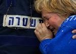 En israelsk politimand trøster en af indbyggerne i Sderot, efter at missil slog ned tæt på hendes hjem i går. 
