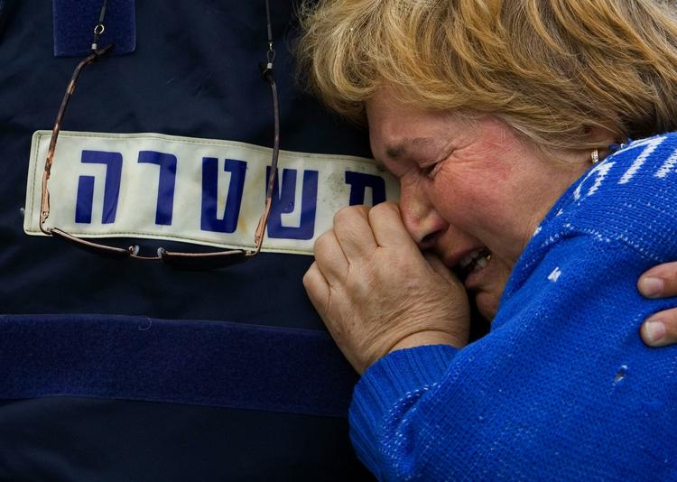 En israelsk politimand trøster en af indbyggerne i Sderot, efter at missil slog ned tæt på hendes hjem i går. 