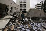 En palæstinenser går igennem ødelæggelserne i Gaza By, 