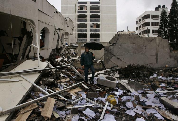 En palæstinenser går igennem ødelæggelserne i Gaza By, 