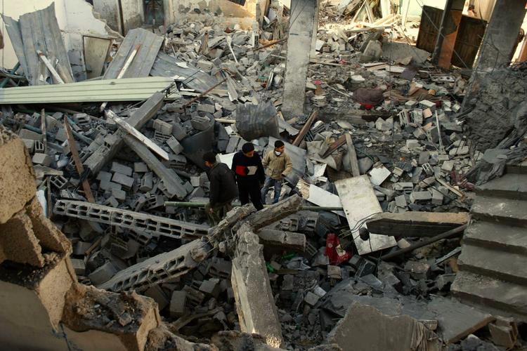 Palæstinensere inspicerer resterne af et hus ved Rafah-flygtningelejren i Gaza efter et israelsk angreb. 