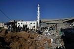 Israelerne har i nat og i dag fortsat de massive bombeangreb i Gaza. Billedet her er fra i går, hvor palæstinensere betragter ødelæggelserne efter et angreb i flygtningelejren Rafah i den sydlige del af Gazastriben. 
