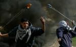 Hamas afviser at indgå våbenhvile, sådan som FN-resolution kræver det. På billedet ses demonstranter på Vestbredden, der kaster sten efter israelske soldater nær Ramallah. 