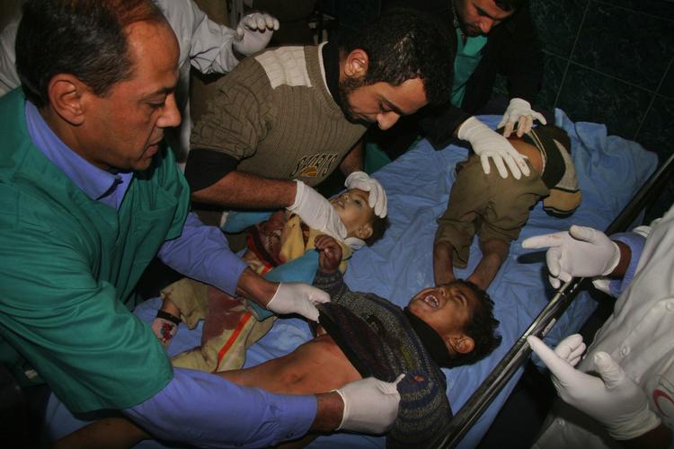 Palæstinensiske hospitalsfolk tilser sårede børn i Gaza By mandag. 