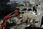 En bulldozer rydder brokkerne af et privat hjem, som er pulveriseret af et israelsk flyangreb. Her døde blandt andet Kaukab al Dayah, en fireårig palæstinensisk pige. Mindst 250 palæstinensiske børn er dræbt af angrebene indtil videre. 