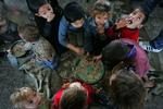 Palæstinensiske børn der sammen med deres familier har forladt deres hjem, spiser på  FN-skolen i Jebaliya-flygtningelejren i den nordlige Gaza-stribe. 