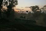 Israelske soldater rykker frem i pansrede mandskabsvogne mod kampzonen i Gaza. 