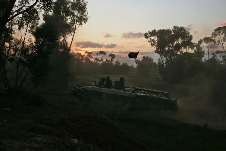 Israelske soldater rykker frem i pansrede mandskabsvogne mod kampzonen i Gaza. 
