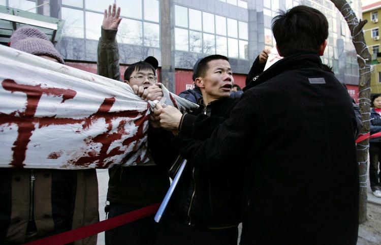 Vrede kinesere foran en byggeplads i Beijing i går. De har ikke fået løn. 