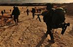 Israelske soldater på march mod Gaza, hvor kampene her til morgen fortsatte. 