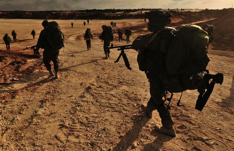 Israelske soldater på march mod Gaza, hvor kampene her til morgen fortsatte. 