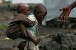 To flygtningebørn forcerer mudderet i en af Afrikas mange flygtningelejre. Arkivfoto. 