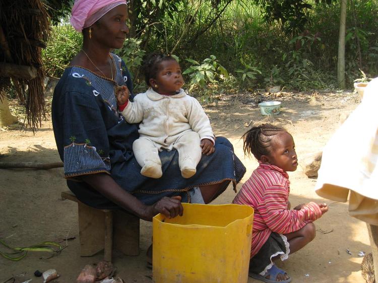 En kvinde fra diamant-områderne i det nordlige Sierra Leone søger skygge for solen med to af sine børn. Foto: Michael Bech 