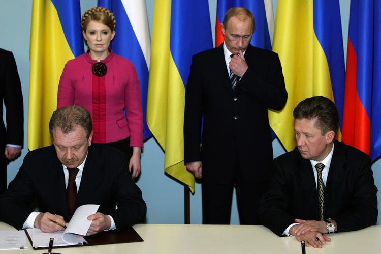 Den russiske premierminister Vladimir Putin og hans ukrainske kollega Julia Timosjenko ser til, mens cheferne for de statslige gasselskaber i går skrev den ny gasaftale under. 