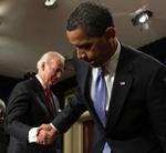 Barack Obama, forrest, trykker vicepræsident Joe Biden i hånden efter at have underskrevet en række papirer i forbindelse med sit nye virke i Det Hvide Hus. 