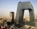 Solen står op over Beijing efter en nat, der har forvandlet hotel Mandarin Oriental (til venstre) til et tomt skelet. Bygningen til højre er tv-stationen CCTV's hovedkvarter. 