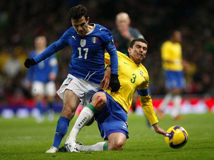Brasiliens anfører, Lucio, går hårdt til Guiseppe Rossi. 