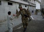 En Pakistans soldater deler slik ud til en dreng i den pakistanske Swat-dal, der er plaget af hårde kampe mellem militante islamister og regeringstropper.  Arkivfoto 
