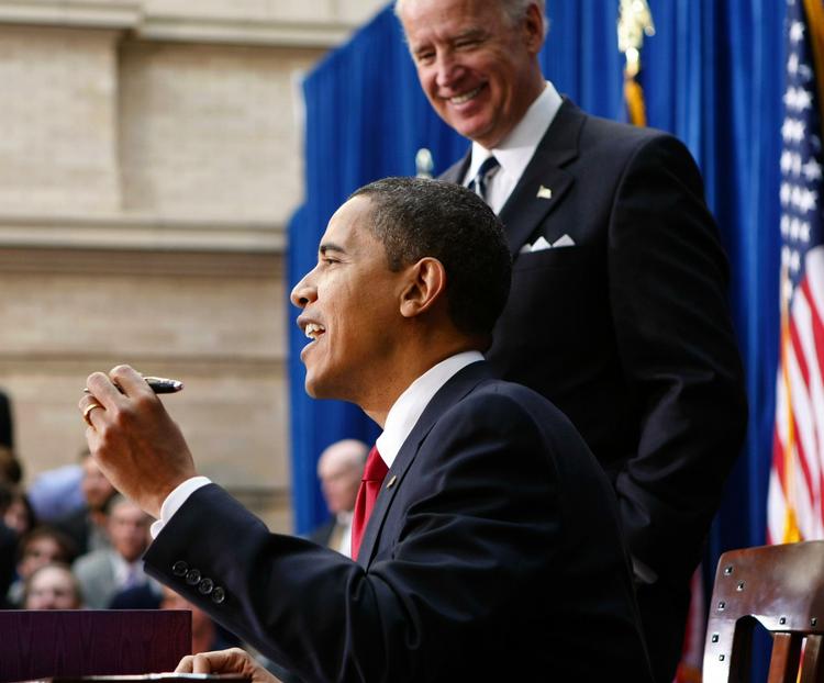 USA's præsident Barack Obama underskriver hjælpepakken under overværelse af sin vicepræsident Joe Biden. 
