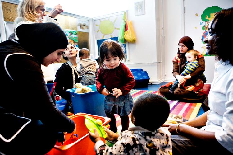 Institutionen Kringlebakken i Københavns Nordvestkvarter forsøger at hjælpe socialt isolerede indvandrerkvinder ved at opsøge dem. »Det er dejligt at møde andre kvinder, når vi taler og har fællesspisning, ud over at jeg lærer dansk«, siger Comford Ayenab fra Ghana (yderst til højre), der sidder med sønnen Claus. 