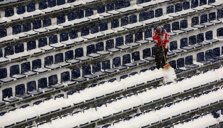 Der var småt med tilskuere på skistadion onsdag formiddag. Her er en person igang med at fjerne sne fra tilskuerpladserne. 