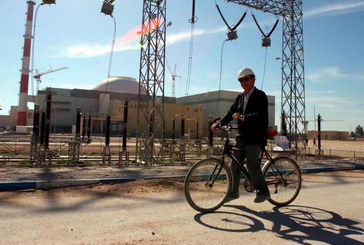 En russisk tekniker cykler forbi det atomanlæg i Bushehr, som Iran regner med at kunne åbne i år. Arkivfoto 