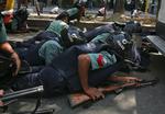 Politistyrker søger dækning udenfor de paramilitære styrkers hovedkvarter i Bangladesh' hovedstad, Dhaka. 