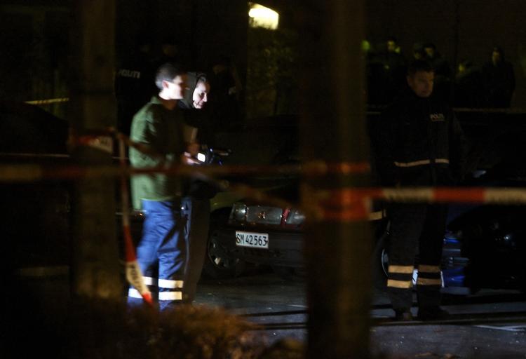 Politiet på gerningsstedet i aftes. Skudhuller i bildøren vidner om et målrettet drab (se billede nederst i artiklen). 