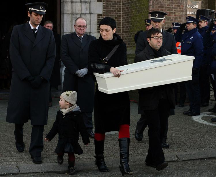 Et forældrepar bærer kisten med deres barn, som blev stukket ihjel i en vuggestue i Belgien. Barnet blev begravet i slutningen af januar. 