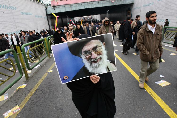 Iran kunne 10. februar fejre 30 års dagen for den islamiske revolution, som afsatte shahen. Her bærer en kvinde et billede af landets åndelige leder ayatollah Ali Khamenei. 