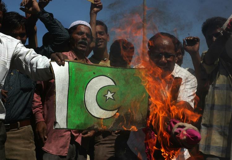 Vrede indere brænder Pakistans flag af i protest mod attentaten mod det srilankanske cricketlandshold i Pakistan i går. 