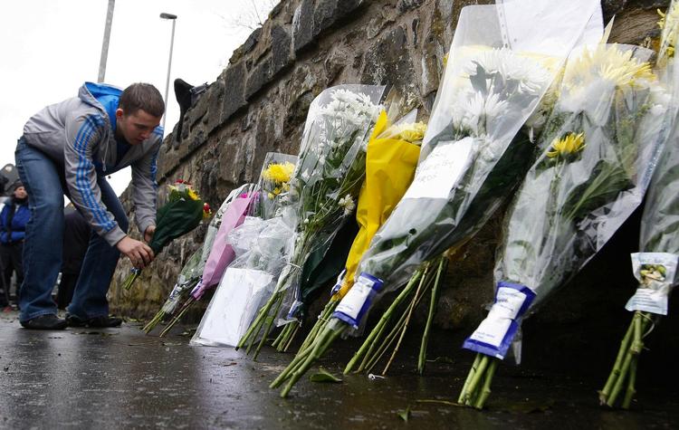 Folk har dagen igennem lagt blomster ved kasernen i Antrim, Nordirland, hvor to britiske soldater blev skudt. 