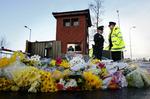 Nordirske politibetjente foran Massereene-kasernen, hvor der er lagt blomster til ære for de to dræbte ofre for lørdagens terrorangreb. 