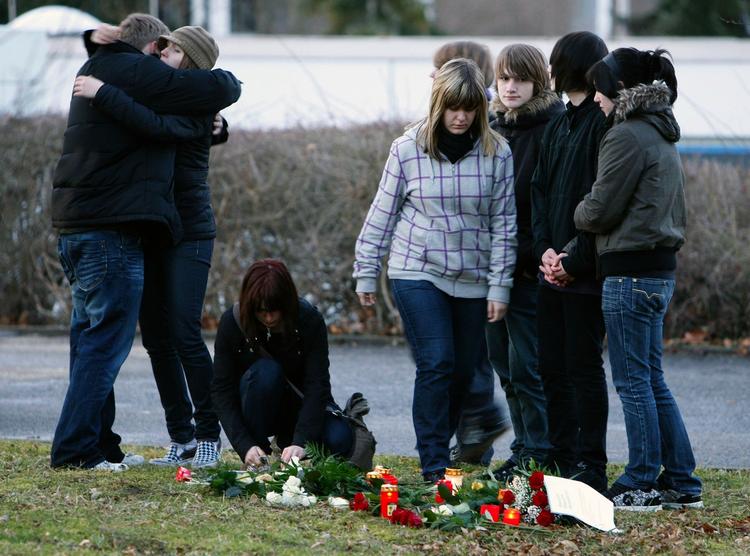 Chokerede børn mødes ved skolen, hvor en 17-årig tidligere elev skød og dræbte ni elever og tre lærere. Senere skød han yderligere tre personer under sin flugt. 