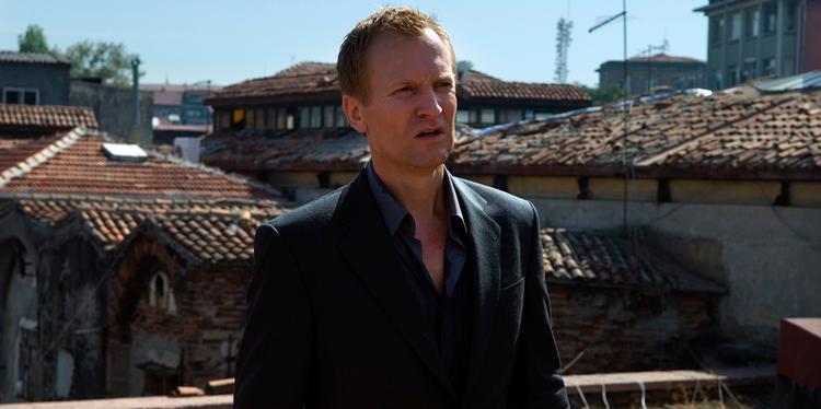 I tyske Tom Tykvers nye film spiler Ulrich Thomsen det,  danske skuespillere gør mest i  internationale film for tiden: en sleben skurk. Foto: Sony Pictures 