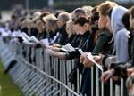 Tyskere synger, mens de overværer mindehøjtideligheden på en storskærm. 