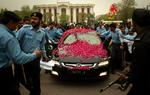 Pakistansk politi eskorterer Iftikhar Chaudrys blomstersmykkede bil. 