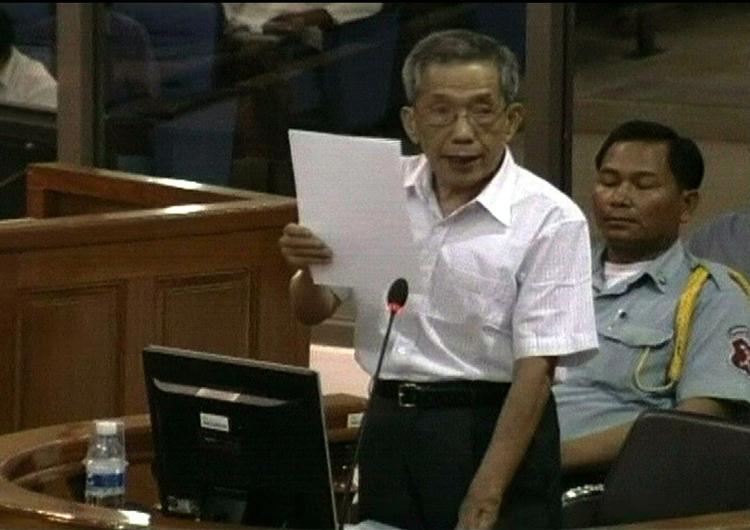 Kaing Guek Eav, kendt som 'Duch', læser en erklæring op for tribunalet i Phnom Penh. Han er tiltalt for talrige grusomheder og drab. 