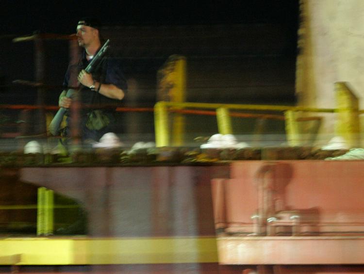 En bevæbnet soldat står vagt på 'Maersk Alabama', da det store containerskib anløber havnen i Mombasa lørdag aften dansk tid. 