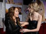 Miley Cyrus (t.v.) spiller hovedrollen i 'Hannah Montana'. Her ses hun til premieren med veninden, countrystjernen Taylor Swift, der også spiller med i filmen. Arkivfoto. 