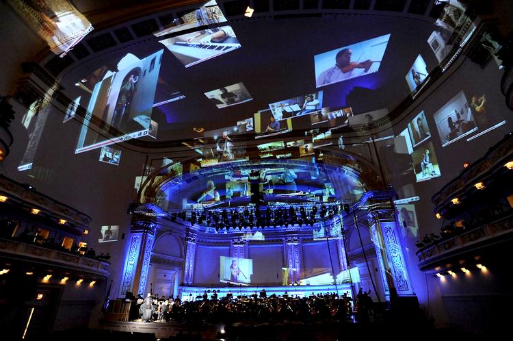 Carnegie Hall i onsdags. 96 musikere spiller sammen i salen, mens storskærme viser deres audition-videoer. Foto: Stefan Cohen/AP 