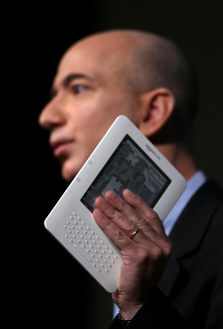 Amazon.com's administrerende direktør, Jeff Bezos, med den nye Kindle. Designet er ikke optimalt, og måske kan den ikke konkurrere med de lækreste bøger. Men den vejer mindre end en bog, du kan søge i teksten, og den er let at betjene med én hånd. Arkivfoto: Mark Lennihan/AP 