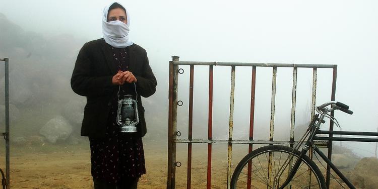 Der er smukt, men djævelsk ensomt og altid tåget på landet i Iran, hvor kvinden Rana (billedet) cykler rundt med de petroleumslamper, hun og hendes far lever af at reparere. Fra 'A Light in the Fog'. Foto fra filmen 