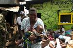 En kvinde med sin baby er blevet alvorligt såret i kampe mellem politiet og den voldelige bande Mungiki i en slum i Nairobi, 2007. 