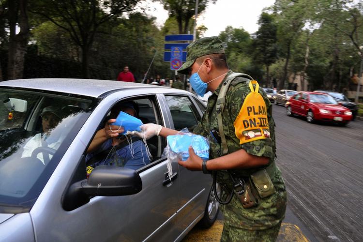 Det mexicanske militær er sendt på gaden for at dele masker ud til borgere for at forebygge smitte af svineinfluenza. 